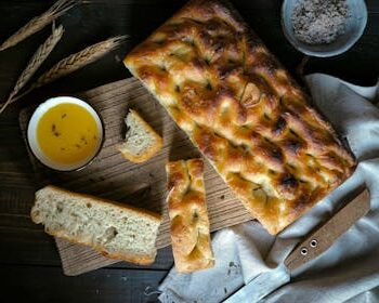Freshly baked homemade focaccia bread served with olive oil, showcasing rustic charm.